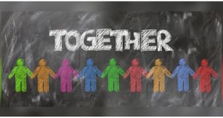 Ζωγραφιά με πολύχρωμα ανθρωπάκια που πιάνονται χέρι – χέρι με το μήνυμα να είναι μαζί