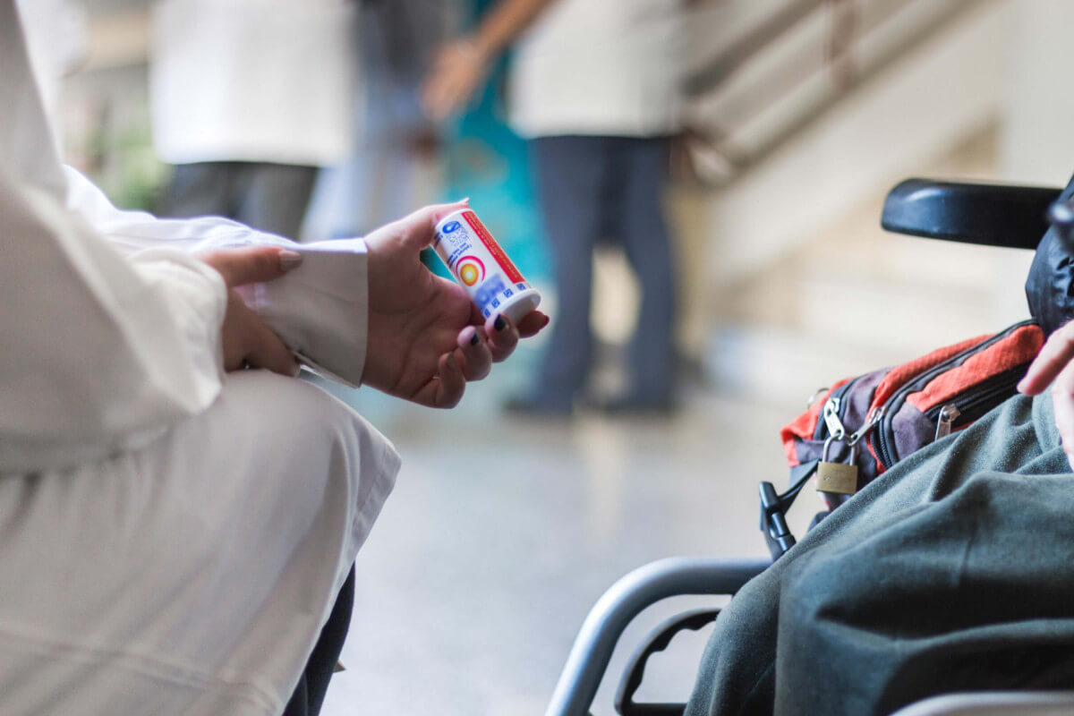 givemed νοσηλευτής δίνει φάρμακα σε ασθενή σε ειδικό αμαξίδιο νοσοκομείο