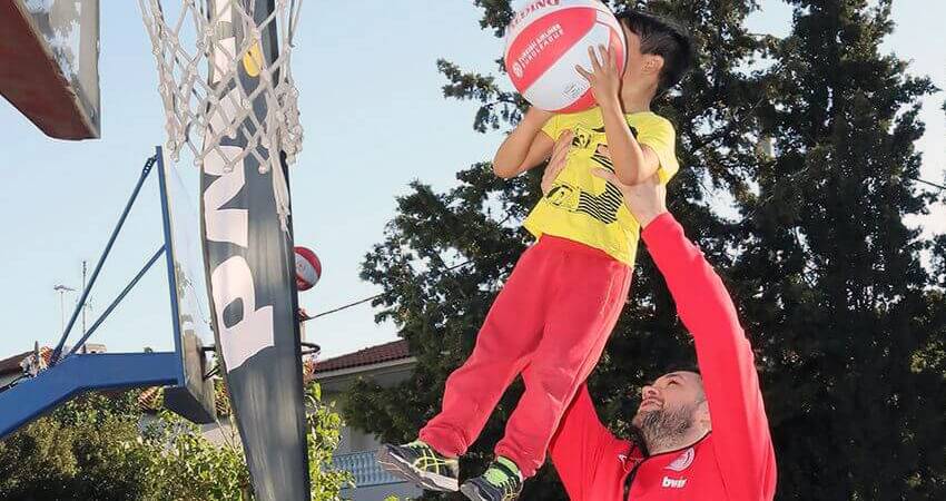 filoitoupediou.gr μπασκετμπολίστας παίζει μπασκετ με παιδί της οργάνωσης σε γήπεδο  | YouBeHero