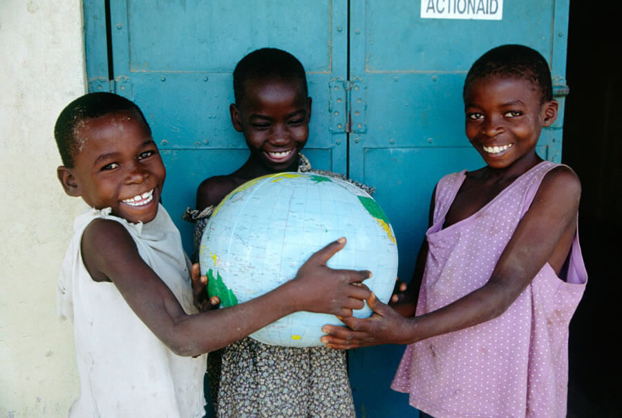 actionaid.gr παιδιά στην Αφρική χαμογελάνε και κρατάνε μία υδρόγειο | YouBeHero